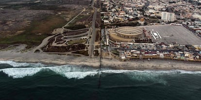 TOPSHOT - Aerial view of the United States (L) - Mexico (R) border fence extending into the Pacific ocean at Playas de Tijuana, Baja California state, Mexico on August 10, 2018. - From the south border with Guatemala to the north border with the United States, AFP met during 24 hours migrants in pursue of their