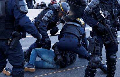 Agents de la policia francesa bloquegen un manifestant durant el desallotjament.