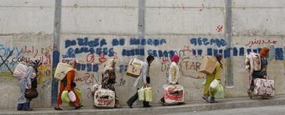 Un grupo de mujeres transporta mercancías desde Ceuta a Marruecos por la fuerte pendiente que desemboca en el puente de Biutz.