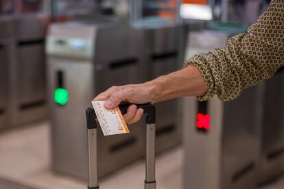 Una viajera sostiene un billete tras cruzar los tornos de una estación.