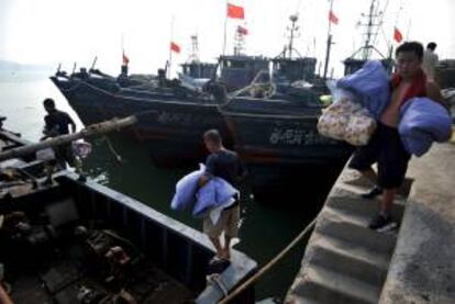 Un pescador carga sus pertenencias en un barco antes del inicio de la temporada de pesca, en un muelle de Qingdao city (China). EFE/Archivo