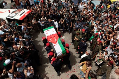 Miembros de las fuerzas de seguridad de Hamas introducen el féretro con los restos del activista italiano Vittorio Arrigoni, asesinado la semana pasada por un grupo vinculado a Al Qaeda.