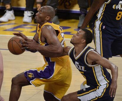 El jugador de los Angeles Lakers Kobe Bryant (i) lucha por el balón con Rodney Hood (d), de los Utah Jazz, durante el partido de la NBA que enfrentó a ambos equipos en el Staples Center en Los Ángeles (Estados Unidos).