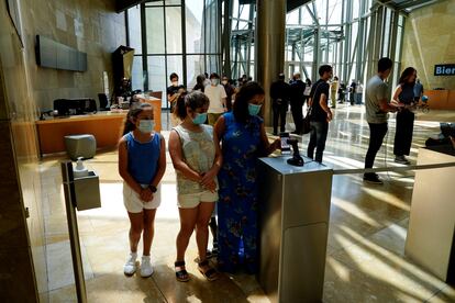 Visitantes usando su móvil a la entrada del museo Guggenheim en Bilbao el 3 de junio.