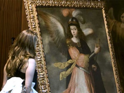 Una joven observa la pintura del arcángel san Miguel recuperada por la policía.