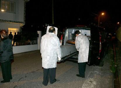 Personal de la funeraria introducen en el furgón el cuerpo sin vida de Juan G.M., muerto por su hijo anoche tras una discusión en Touceda, en la parroquia pontevedresa de Alba.