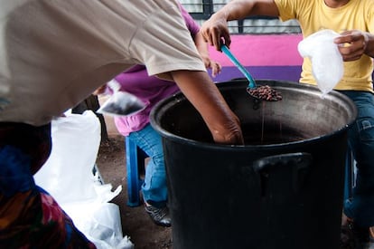 Cuando los 25 kilos arroz y los 10 de frijoles ya están listos, las mujeres y algún voluntario se distribuyen alrededor de las dos grandes ollas y, con grandes cucharones, los reparten en raciones en las bolsas transparentes más pequeñas. Completan el menú con algunas tortillas o panes.