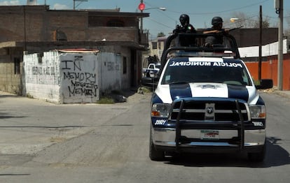 Policía patrullando una de las calles de poniente,al fondo un 'graffiti' de homenaje al uno de los líderes de los Zetas.