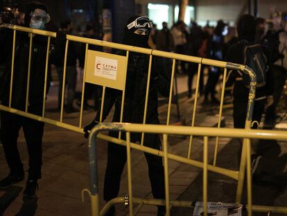 Unos jóvenes cargan unas vallas en la quinta noche de protestas por el encarcelamiento del rapero Pablo Hasél, el sábado.