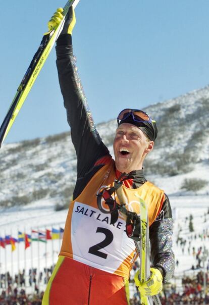 El vencedor de la final de los 30 kilómetros de esquí de fondo, el español Johann Muehlegg, celebra su victoria en la línea de llegada en Salt Lake City 2002. Muehlegg, de origen alemán, consiguió dos oros durante la competición, en la citada categoría de 30 kilómetros de esquí de fondo y en la de 10+10 kilómetros. En 2003, el Comité Olímpico Internacional desposeyó a Muehlegg de sus medallas al acusarle de dopaje en la edición de Salt Lake. El excéntrico esquiador (siempre llevaba una petaca de agua sagrada al competir) formó parte del equipo de Alemania en los Juegos de 1992, 1994 y 1998, edición tras la que fue expulsado por su difícil carácter.