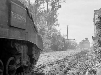 Tanques del Sherwood Rangers pasan junto a un Tiger destruido.