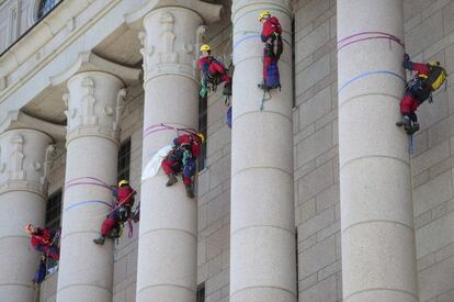 Miembros de Greenpeace suben a las columnas del parlamento finlandés durante una manifestación sobre el cambio climático.
