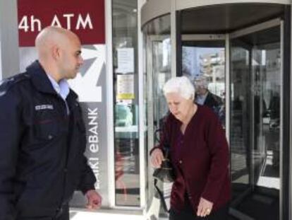 Una mujer abandona una sucursal de Laiki Bank en Nicosia (Chipre). EFE/Archivo