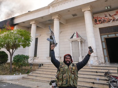Opposition fighters celebrate as they burn down a military court in Damascus, Syria, Sunday, Dec. 8, 2024. (AP Photo/Hussein Malla)