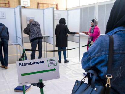 Ciudadanos depositan sus votos en unas cabinas durante las elecciones parlamentarias, en Rotterdam (Holanda).