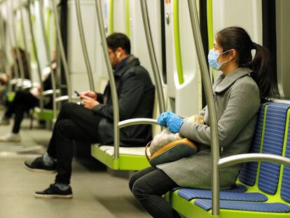 Una mujer viaja con una mascarilla en la linea 2 del metro de Valencia.