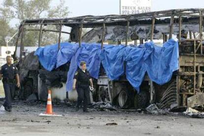 Miembros del equipo de emergencias inspeccionan el autobús incendiado en el que murieron 24 personas cuando estaban siendo evacuadas de Houston.