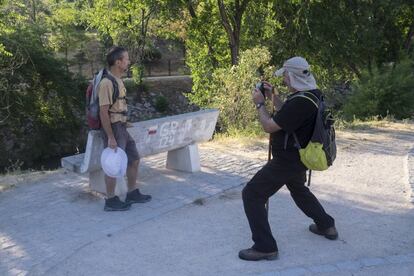 Juan García retrata a su compañero de Ecologistas en Acción Jesús Sánchez junto a un banco en el Parque Lineal del Manzanares marcado con la ruta GR 124.