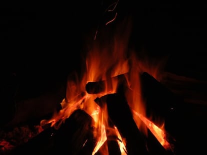 Experimento en el que piedras de silcreta se calientan en la arena con un fuego.