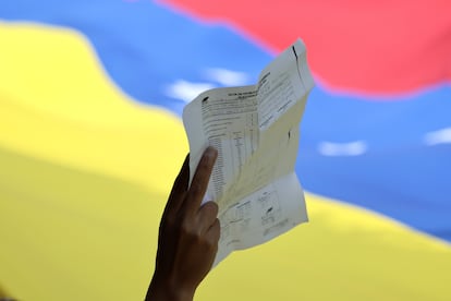 Una persona sostiene una copia de un acta de votación, durante una manifestación en rechazo a los resultados del Consejo Nacional Electoral (CNE), en las elecciones presidenciales del domingo pasado que dieron como ganador a Nicolás Maduro, este sábado en la Ciudad de México.