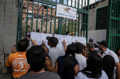 Ciudadanos buscan sus nombres en una lista afuera de un colegio electoral durante las elecciones presidenciales del 28 de julio de 2024 en Caracas, Venezuela.