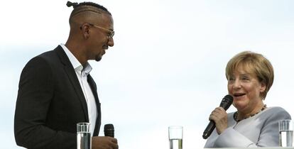 La canciller Angela Merkel habla con el futbolista Jerome Boateng el pasado 28 de agosto durante la jornada de puertas abiertas de la Cancillería en Berlín.