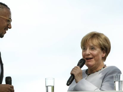 La canciller Angela Merkel habla con el futbolista Jerome Boateng el pasado 28 de agosto durante la jornada de puertas abiertas de la Canciller&iacute;a en Berl&iacute;n.
 