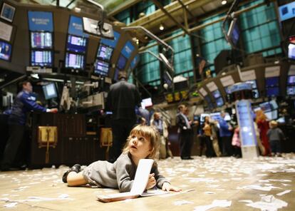 Una pequeña se revuelca en el parqué de la Bolsa de Nueva York. REUTERS