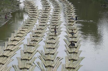 Trabajadores indios transportan bambú en el río Longai, en Damchara.