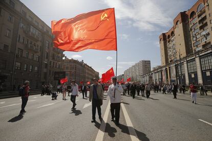 Un hombre ondea una bandera frente a un mitin comunista para conmemorar el 1 de Mayo, en Rusia (Moscú).