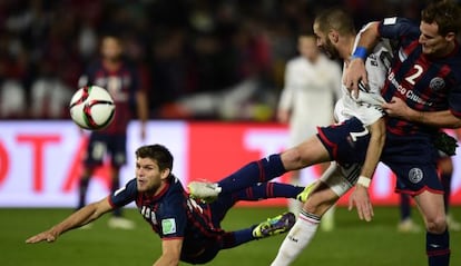 Benzema disputa el bal&oacute;n con Kannemann y Cetto, de San Lorenzo. 