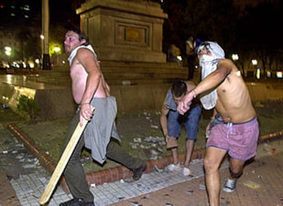 Participantes en las protestas contra el nuevo Gobierno argentino lanzan piedras contra la sede del Gobierno en Buenos Aires.
