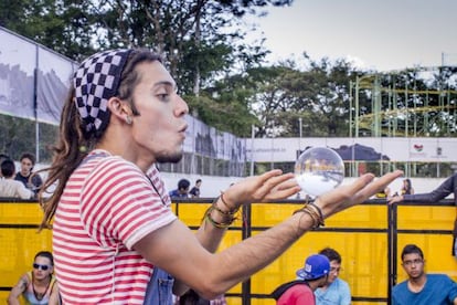 Um jovem faz malabarismo com uma esfera de cristal no Festival Altavoz de Medellín.