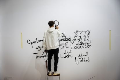 Zakaria Ezzouyn, pintando un mural con palabras elegidas por los futbolistas del FC Darna, el martes en la sala de la exposición 'Goals for Change'.