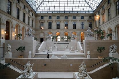 Un trabajador del Louvre camina por el interior del museo el 13 de marzo, cuando el museo cerró sus puertas.