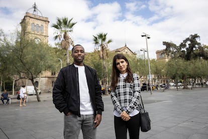 Bienvenu Iradukunda y Lina Fazly, dos refugiados con estudios superiores, en la plaza de la Universitat, con el edificio antiguo de la Universidad de Barcelona al fondo.