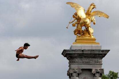 Un nadador realiza un ejercicio desde el puente Alexandre III sobre el río Sena con motivo de las Jornadas Olímpicas Internacionales que se celebran en París.