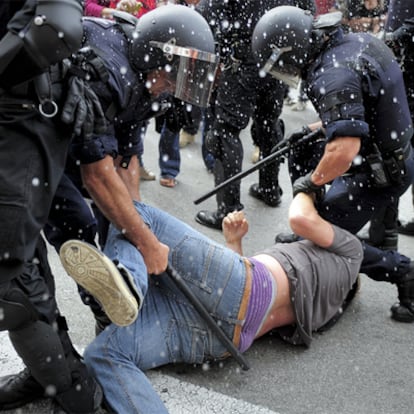 Dos policías arrastrando a un manifestante en la plaza de Catalunya.