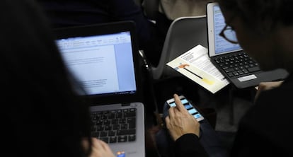Dos personas trabajan con ordenadores portátiles.