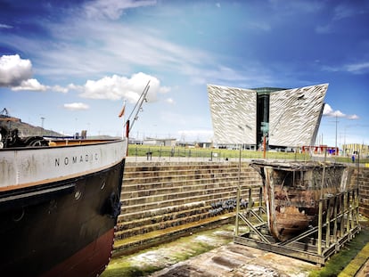 El 'El SS Nomadic' y, al fondo, el museo Titanic Belfast, en la capital de Irlanda del Norte.