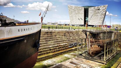 El 'El SS Nomadic' y, al fondo, el museo Titanic Belfast, en la capital de Irlanda del Norte.