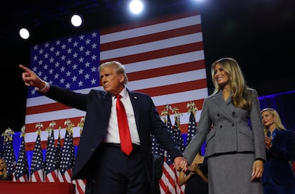 Donald Trump gestures as he holds hands with his wife Melania at the Palm Beach County Convention Center on Wednesday.