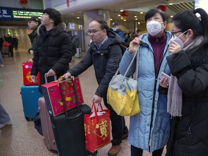 Um grupo de viajantes usa máscaras na Estação Ferroviária Oeste de Pequim nesta terça-feira.