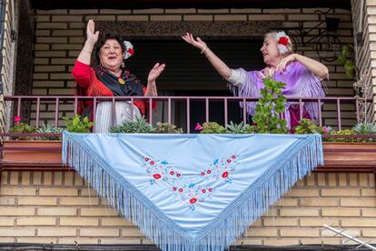 María Encarna y Amparo (derecha), vestidas con sus refajos de huertanas en el balcón de su casa de Murcia, en el día grande de las Fiestas de Primavera, suspendidas por la pandemia del Covid-19, este martes, trigésimo primer día del estado de alarma decretado por el Gobierno para frenar la pandemia del coronavirus.