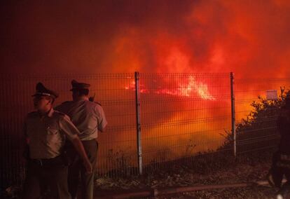 Dos policías controlan una zona cerca de las colinas de Valparaíso, donde el fuego ha arrasado 260 hectáreas.