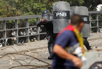 Un oficial de la policía venezolana dispara balas de goma contra un manifestante durante la manifestación de los opositores en Caracas. 