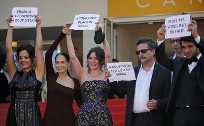 Director Kleber Mendonca Filho (2ndR) and cast members Maeve Jinkings (L), Sonia Braga (2ndL), Carla Ribas (C) and Irandhir Santos hold placards to protest against the impeachment of suspended Brazilian President Dilma Rousseff on the red carpet as they arrive for the screening of  the film "Aquarius" in competition at the 69th Cannes Film Festival in Cannes, France, May 17, 2016.  REUTERS/Jean-Paul Pelissier