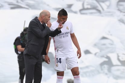 El entrenador francés del Real Madrid, Zinedine Zidane (a la izquierda), da instrucciones al centrocampista brasileño, Carlos Casemiro.