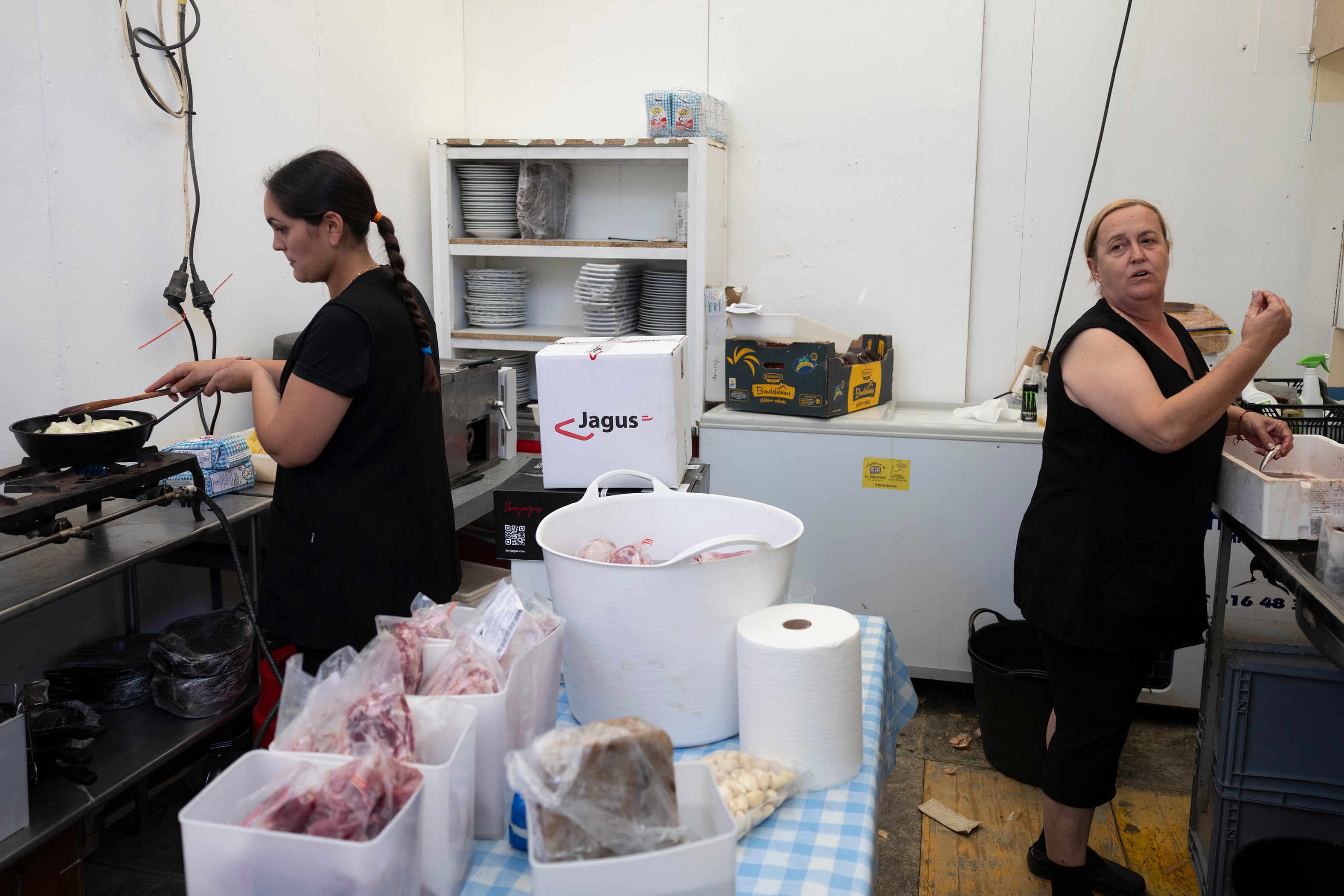 Dolores Palomino (drcha.) y Naima Hamed, en la cocina de una caseta de la feria de Alcalá de Guadaíra (Sevilla), el pasado miércoles.