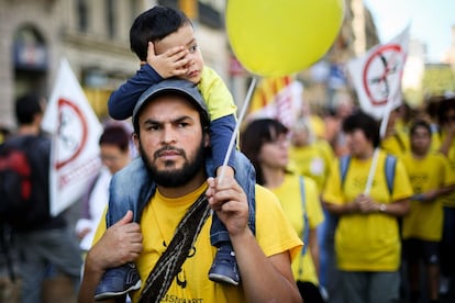 Un padre, junto a su hijo, durante la manifestación en Barcelona en contra de la 'ley Wert'.